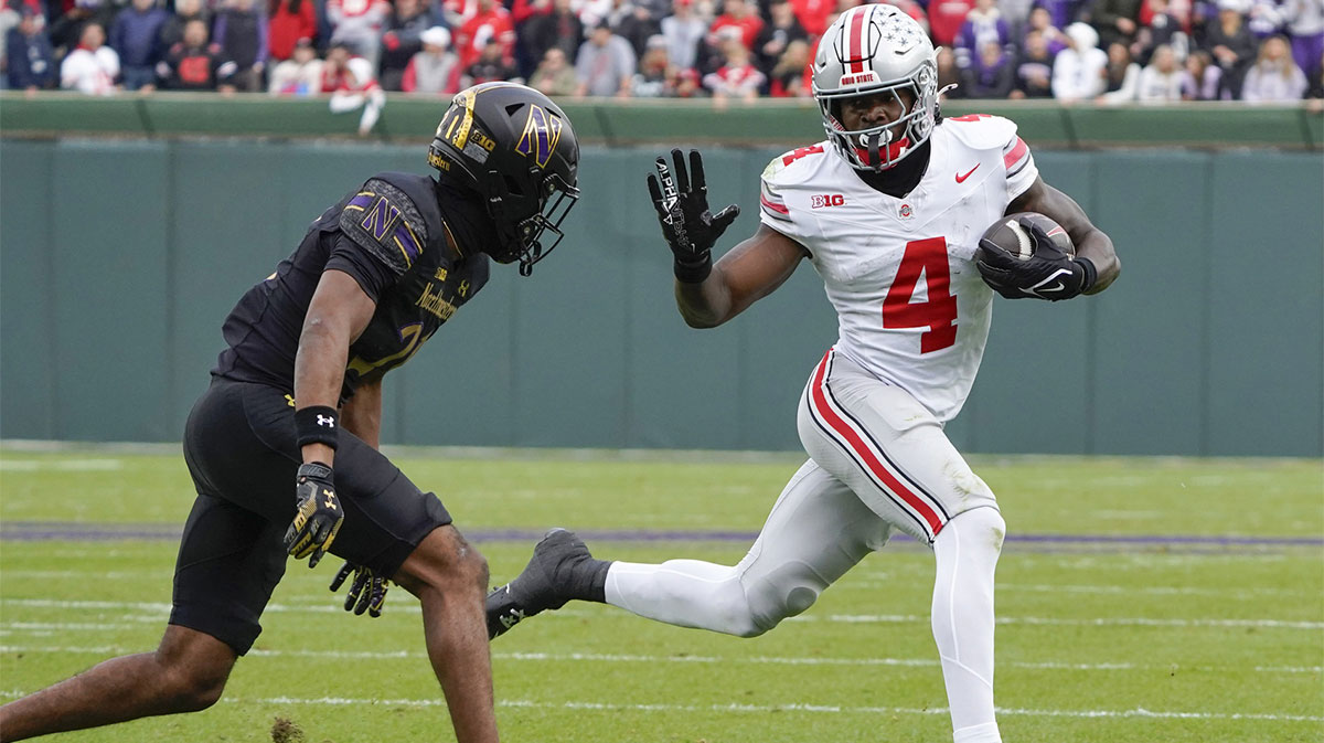 Northwestern Wildcats defensive back Damon Walters (21) tries to tackle Ohio State Buckeyes wide receiver Jeremiah Smith (4) during the second half at Wrigley Field.