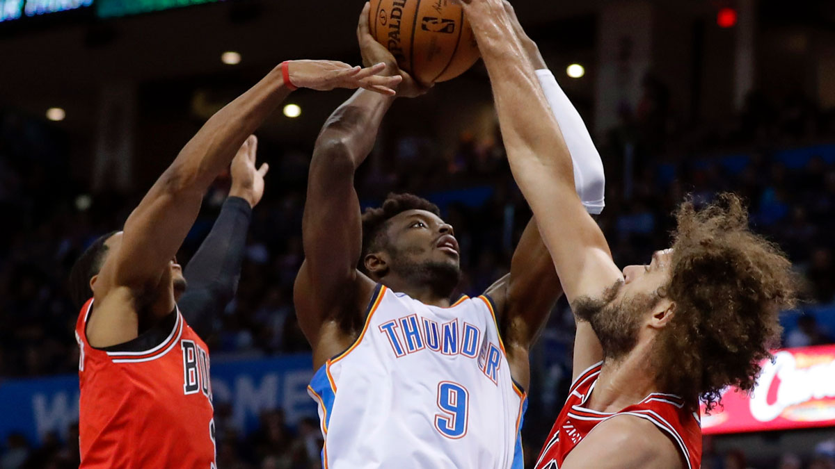 Oklahoma City Thunder forward Jerami Grant, center, goes to the basket between Chicago Bulls guard Shaquille Harrison, left, and Chicago Bulls center Robin Lopez, right, during the first quarter at Chesapeake Energy Arena. 