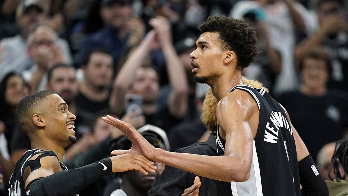 San Antonio Spurs center Victor Wembanyama (1) is congratulated by forward Keldon Johnson (0) and fans after scoring a career high fifty points during the second half against the Washington Wizards at Frost Bank Center.