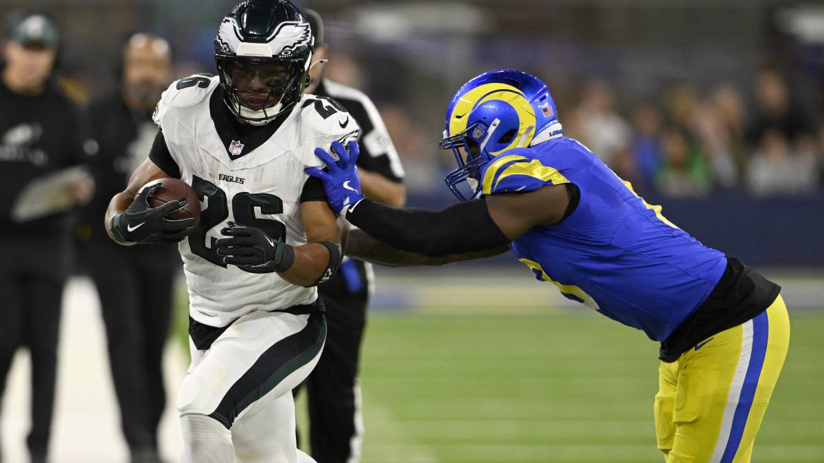Philadelphia Eagles running back Saquon Barkley (26) gets pushed out-of-bound by Los Angeles Rams linebacker Jared Verse (right) during the first half at SoFi Stadium.