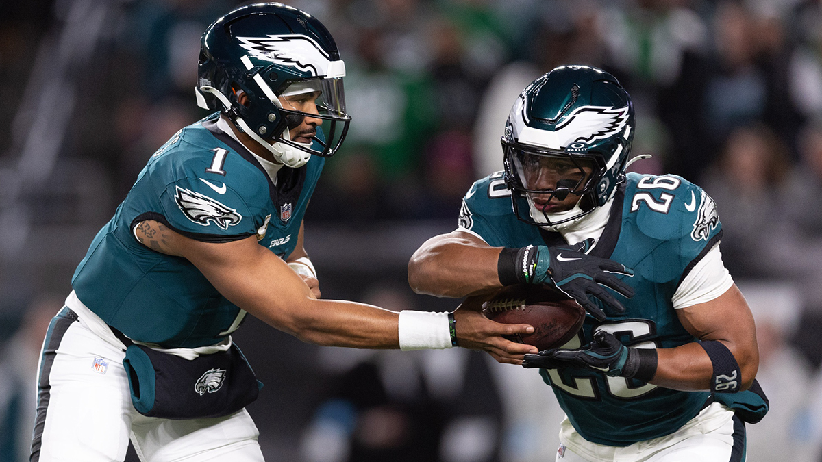 Philadelphia Eagles quarterback Jalen Hurts (1) hands off to running back Saquon Barkley (26) during the first quarter against the Washington Commanders at Lincoln Financial Field.