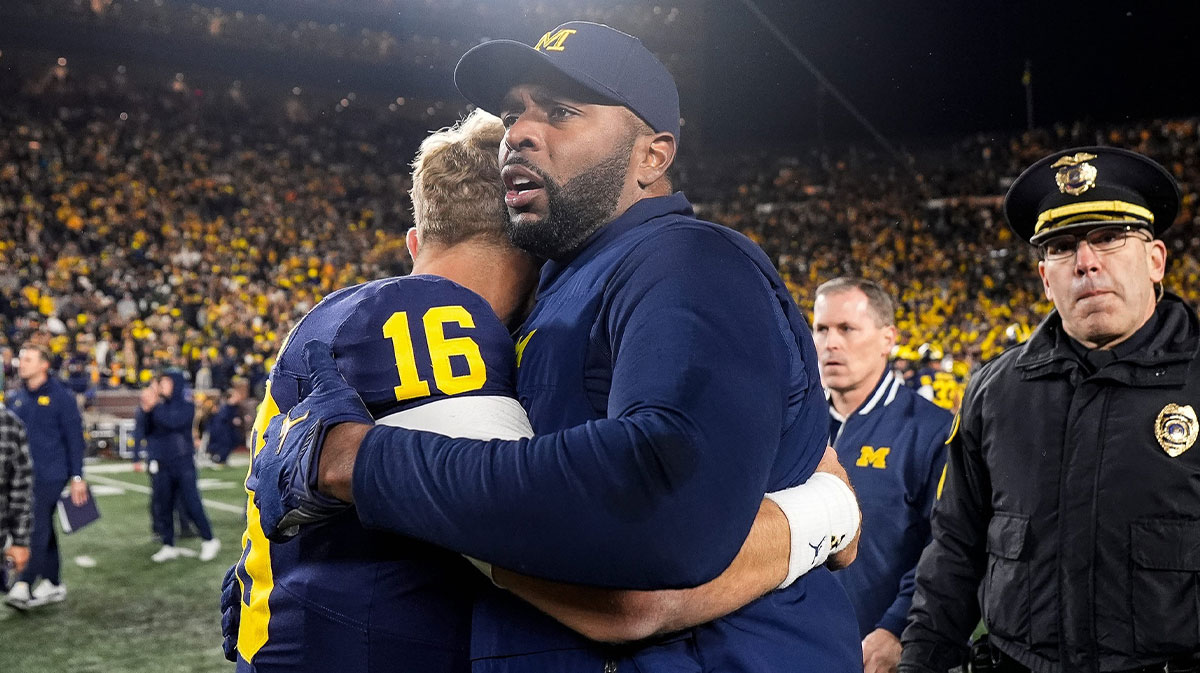 Michigan head coach Sherrone Moore hugs quarterback Davis Warren (16) after 24-17 win over Michigan State at Michigan Stadium