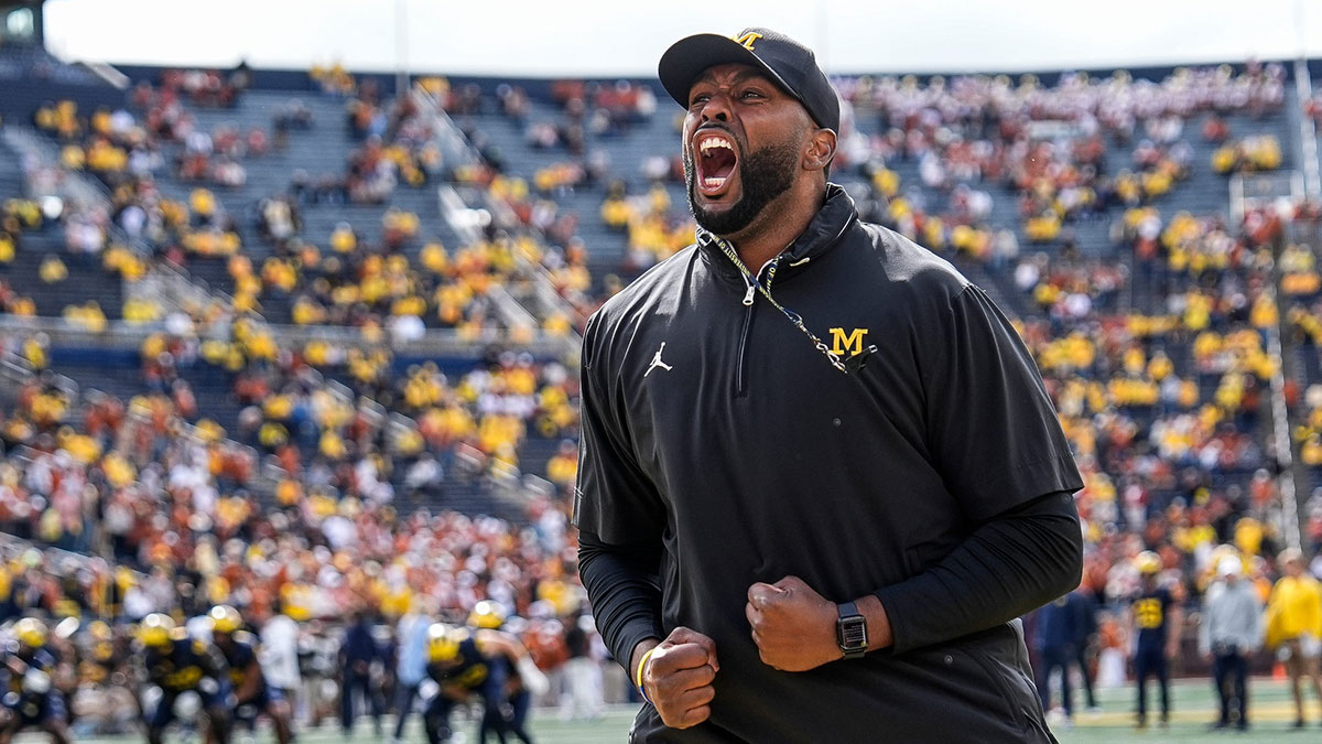 Michigan head coach Sherrone Moore cheers with the student section during warm ups at Michigan Stadium.
