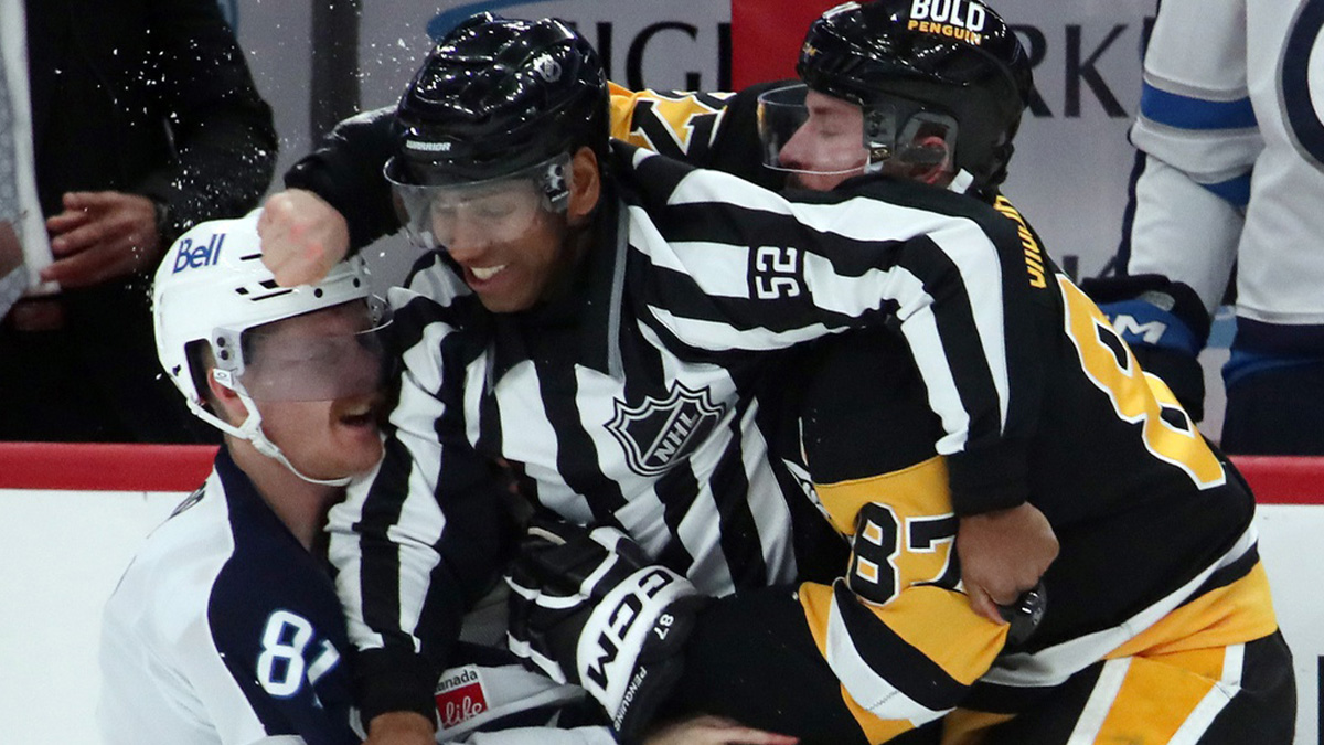 NHL linesman Shandor Alphonso (52) breaks up a fight between Winnipeg Jets left wing Kyle Connor (81) and Pittsburgh Penguins center Sidney Crosby (87) during the second period at PPG Paints Arena.