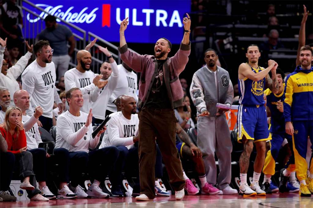 Golden State Warriors guard Stephen Curry reacts on the bench after a basket against the Houston Rockets during overtime at Toyota Center.