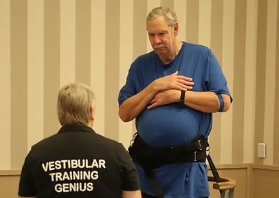 Steve Hayes (blue shirt) completes vestibular training at the 2024 Legends Getaway health screenings. The balance assessment is one exam during the screenings that is especially important as former players get older.