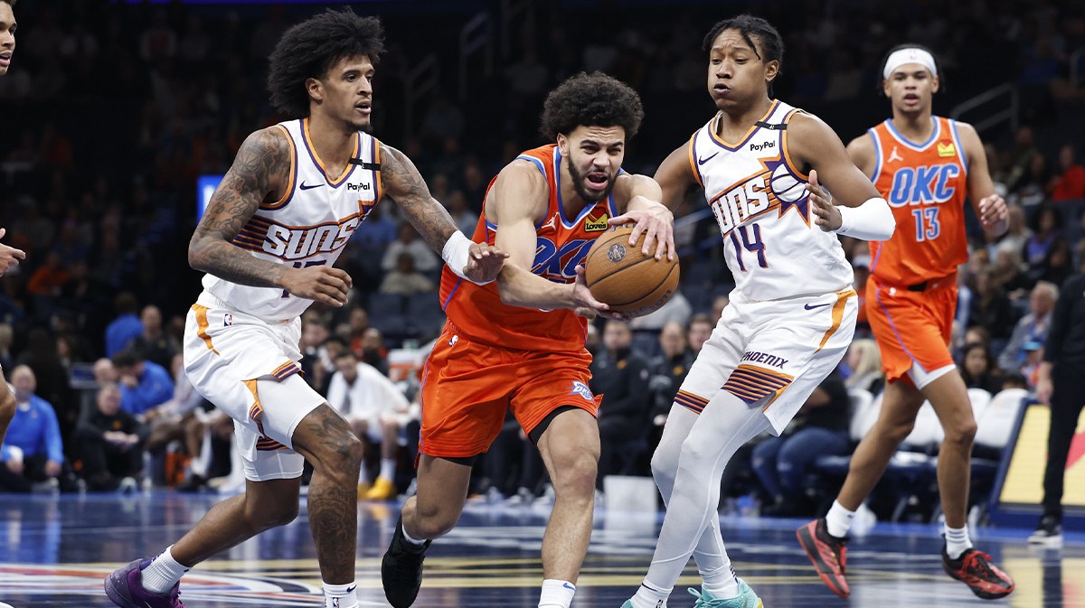 Thunder guard Ajay Mitchell (25) drives to the basket between Phoenix Suns forward Jalen Bridges (15) and guard TyTy Washington Jr. (14)during the fourth quarter at Paycom Center