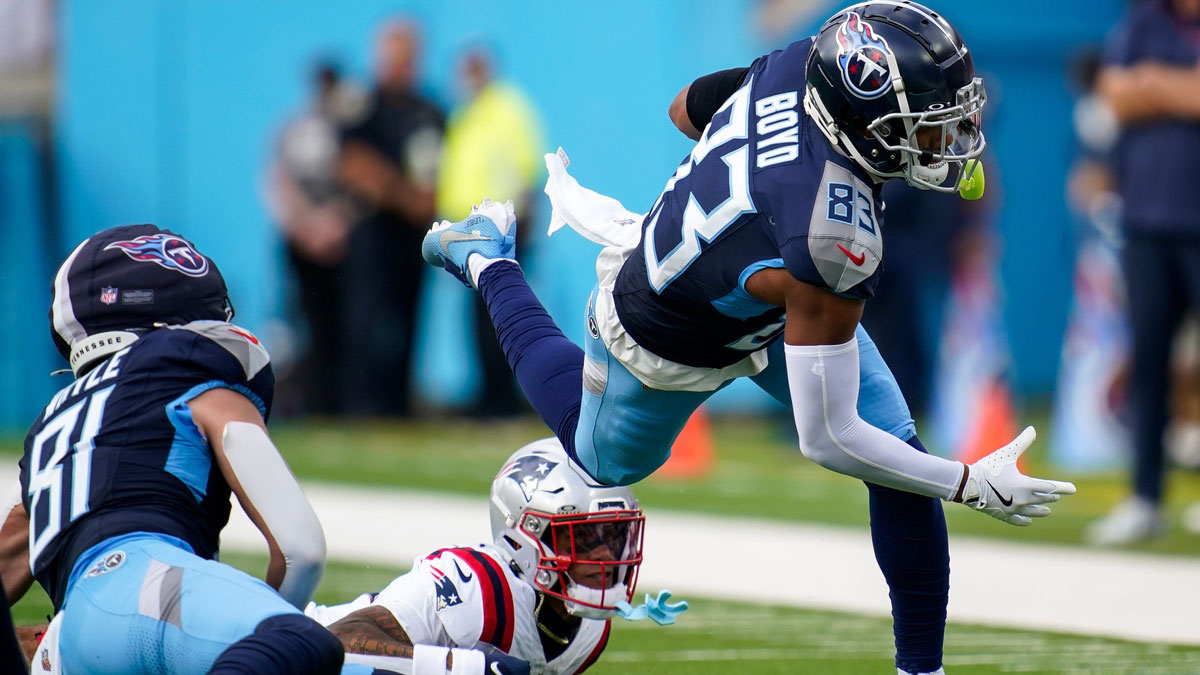 Tennessee Titans wide receiver Tyler Boyd (83) is tripped up by New England Patriots cornerback Christian Gonzalez (0)