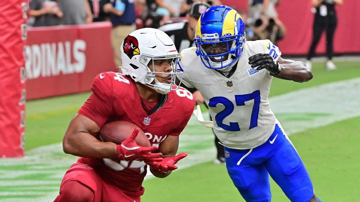 Arizona Cardinals tight end Elijah Higgins (84) catches a touchdown as Los Angeles Rams cornerback Tre'Davious White (27) defends in the first half at State Farm Stadium. 