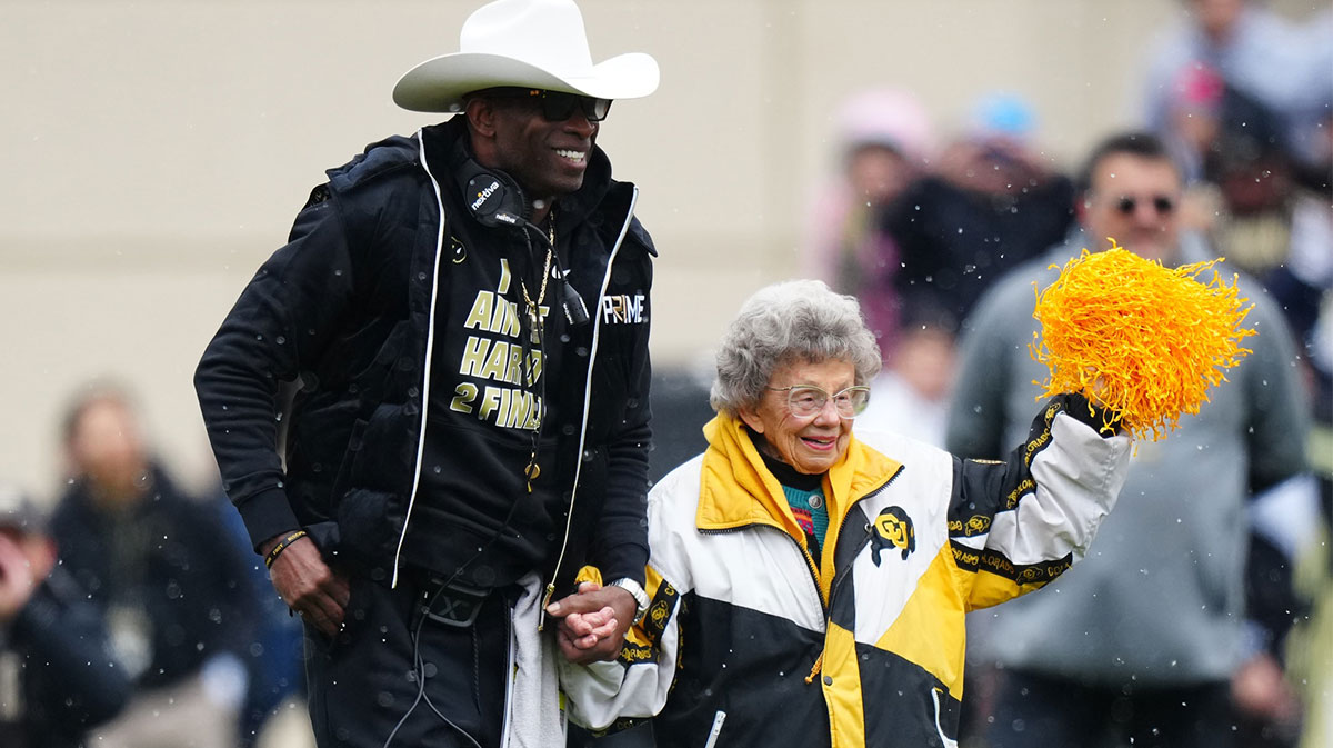 Colorado Buffaloes head coach holds the hand of fan Peggy Coppom before the start of the spring game at Folsom Filed.