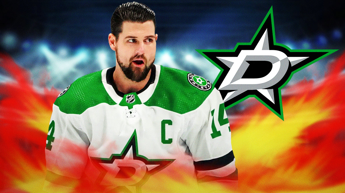 Jamie Benn looking happy with fire around him, Dallas Stars logo, hockey rink in background