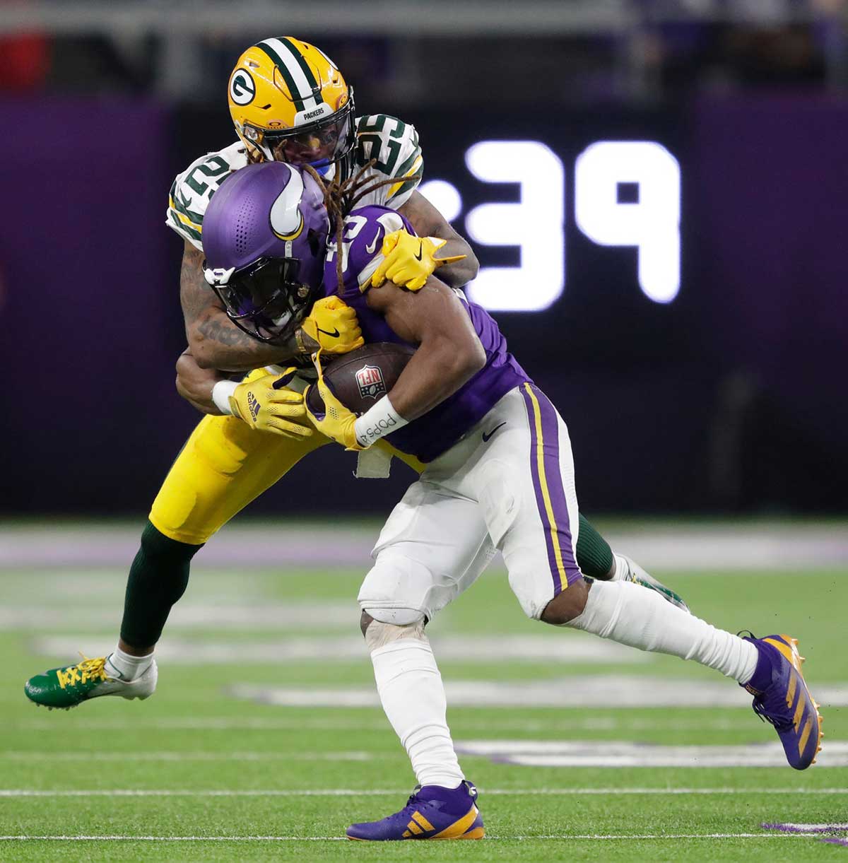 Minnesota Vikings running back Aaron Jones (33) gains a first down on a reception against Green Bay Packers cornerback Keisean Nixon (25) in the third quarter of their football game Sunday, December 29, 2024, at U.S. Bank Stadium in Minneapolis, Minnesota.