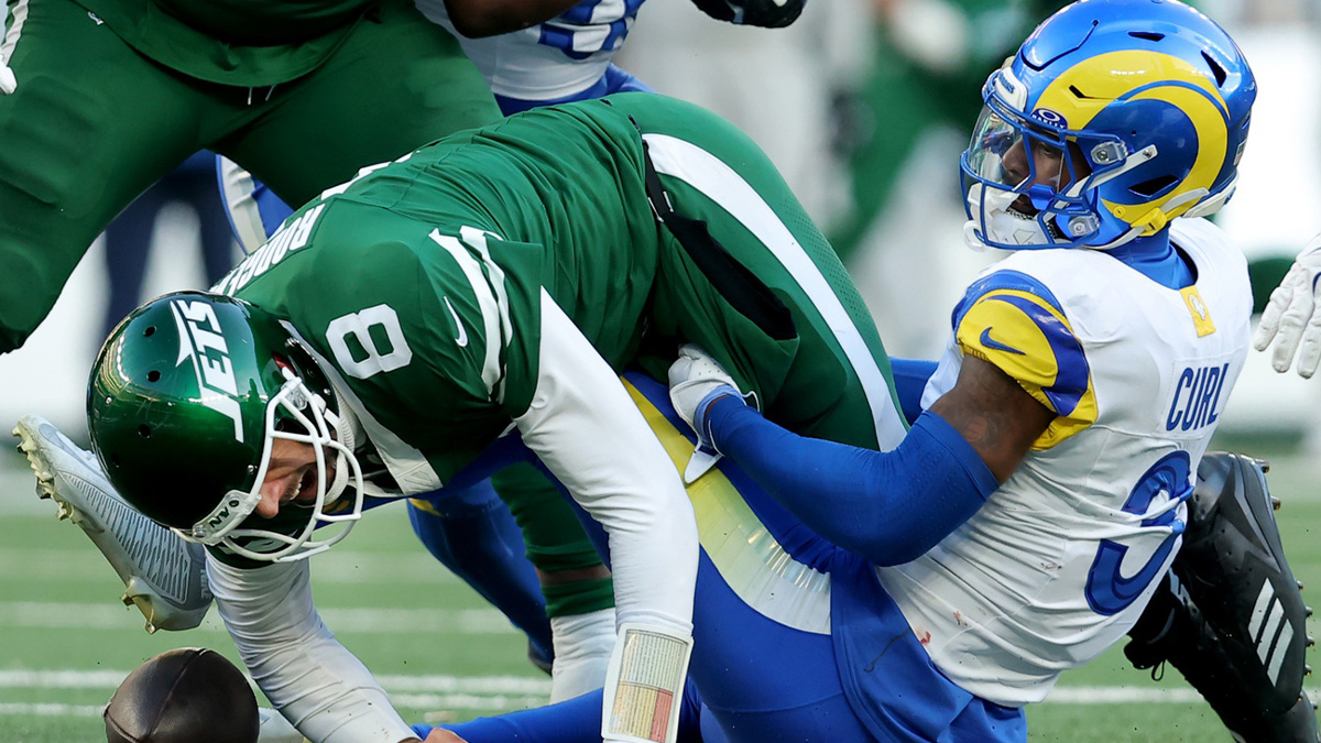 New York Jets quarterback Aaron Rodgers (8) fumbles the ball after a hit by Los Angeles Rams safety Kamren Curl (3) during the fourth quarter at MetLife Stadium.