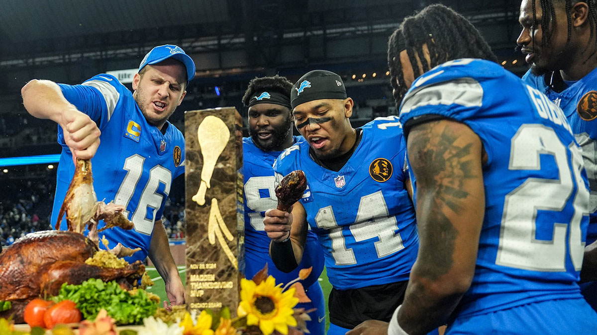 Detroit Lions quarterback Jared Goff (16), defensive tackle DJ Reader (98), wide receiver Amon-Ra St. Brown (14), running back Jahmyr Gibbs (26), linebacker Al-Quadin Muhammad (69) celebrate their win against the Chicago Bears with a turkey drumstick after winning 23-20 on Thanksgiving Day at Ford Field in Detroit on Thursday, Nov. 28, 2024.