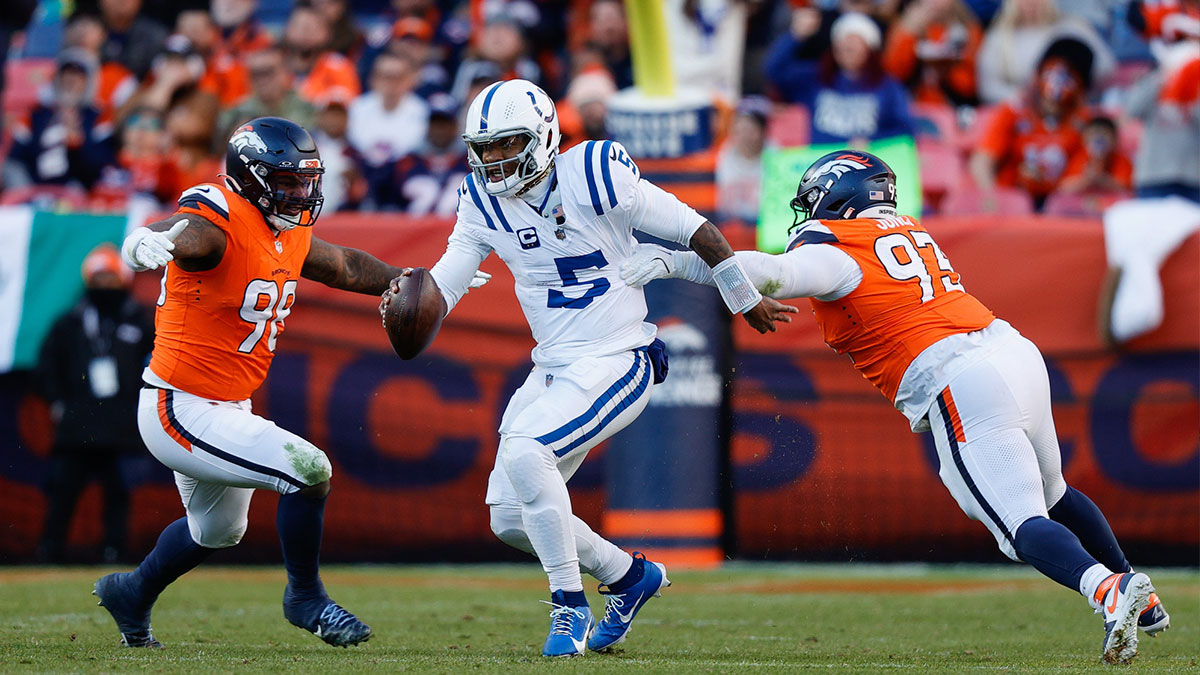 Indianapolis Colts quarterback Anthony Richardson (5) runs through the tackle of Denver Broncos defensive tackle D.J. Jones (93) and defensive end John Franklin-Myers (98) in the second quarter at Empower Field at Mile High.