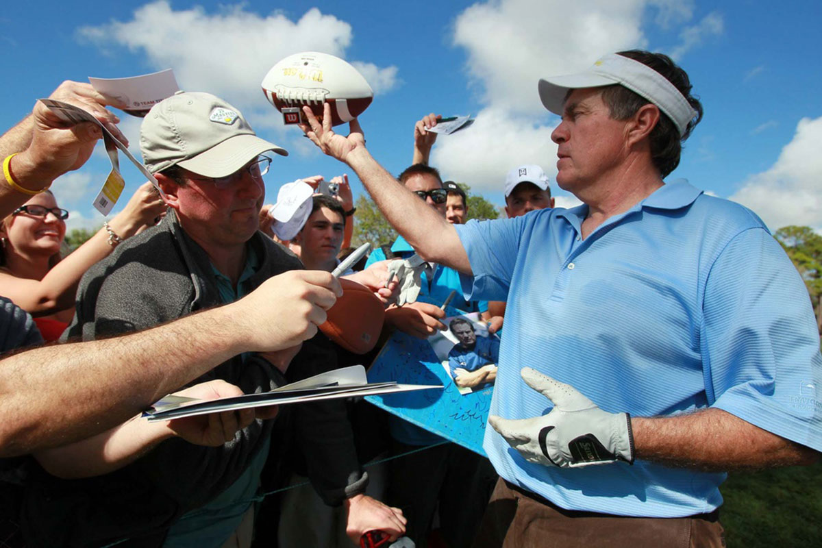 New England Patriots head coach Bill Belichick signs autographs during his pro-am appearance with golfing great Greg Norman, golf star Lexi Thompson, former NFL quarterback and TV commentator Joe Theismann and musician Kenny G at the Honda Classic in 2012.