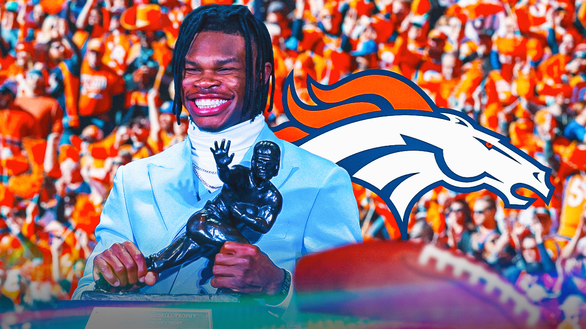 Denver Broncos fans celebrating while Travis Hunter holds the Heisman trophy. Behind Hunter is a Broncos logo. Background is Mile High Stadium.