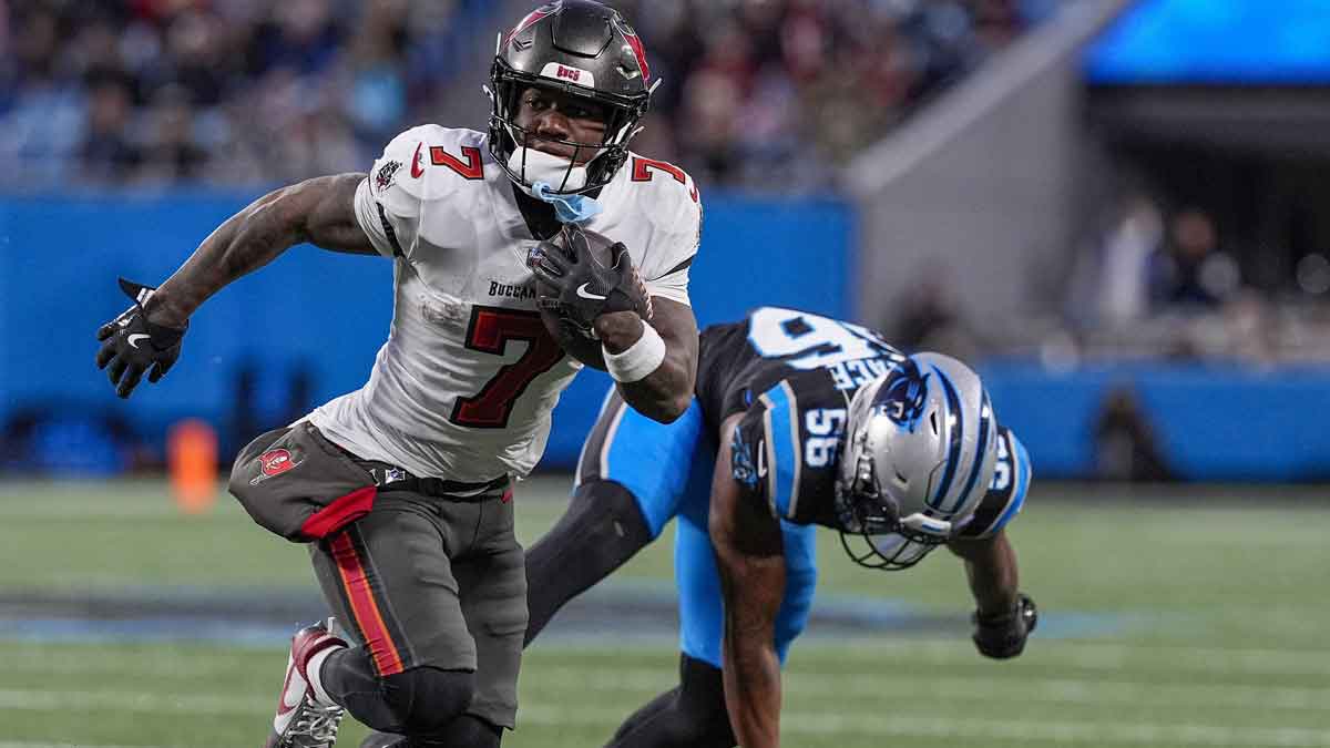 Tampa Bay Buccaneers running back Bucky Irving (7) outruns Carolina Panthers linebacker Trevin Wallace (56) during the second quarter at Bank of America Stadium.