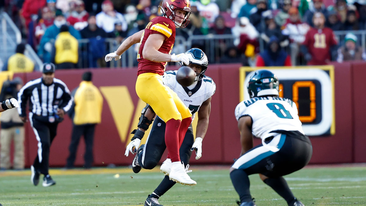 Washington Commanders wide receiver Luke McCaffrey (12) watches as an intended pass intercepted by Philadelphia Eagles safety C.J. Gardner-Johnson (8) during the second quarter at Northwest Stadium.