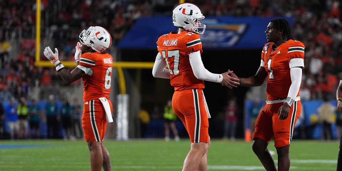 Dec 28, 2024; Orlando, FL, USA; Miami Hurricanes quarterback Emory Williams (17) shakes hands with quarterback Cam Ward (1) after a touchdown against the Iowa State Cyclones during the second half at Camping World Stadium.