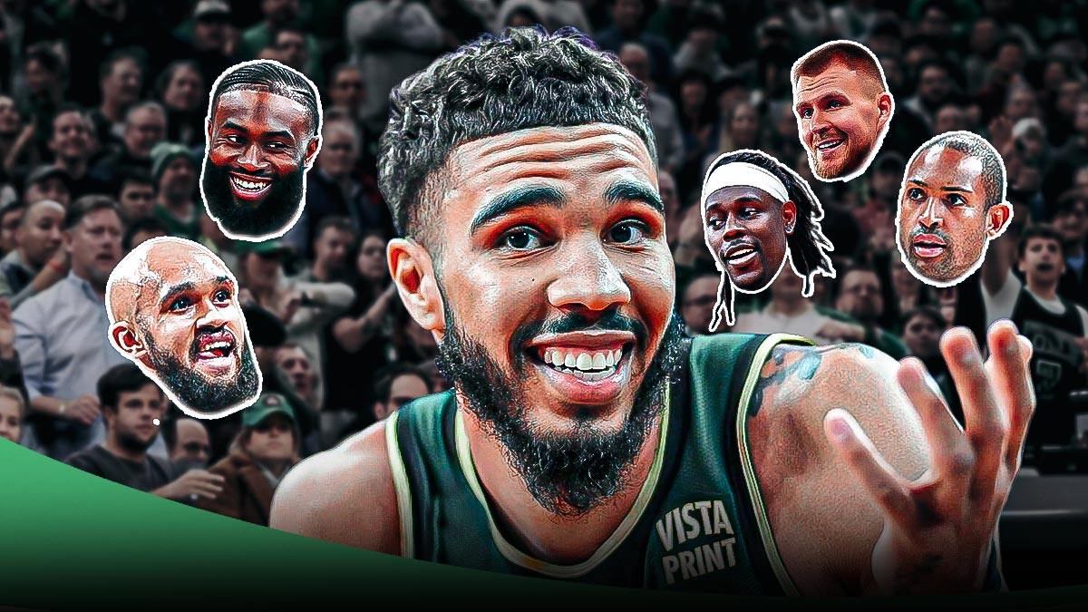 Celtics' Jayson Tatum smiling, with head cutouts