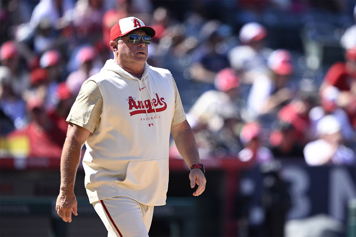 Los Angeles Angels manager Phil Nevin (left) walks to the mound during the seventh inning against the Cincinnati Reds at Angel Stadium.