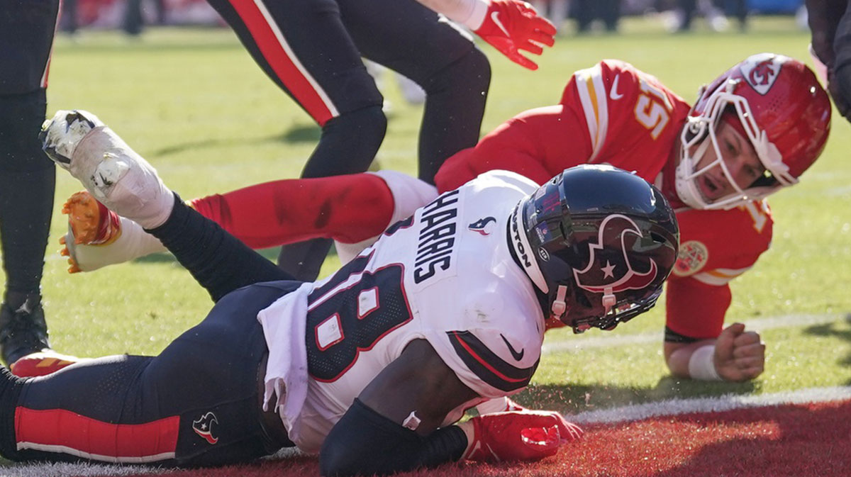 Kansas City Chiefs quarterback Patrick Mahomes (15) runs for a touchdown as Houston Texans linebacker Christian Harris (48) defends during the first half at GEHA Field at Arrowhead Stadium.