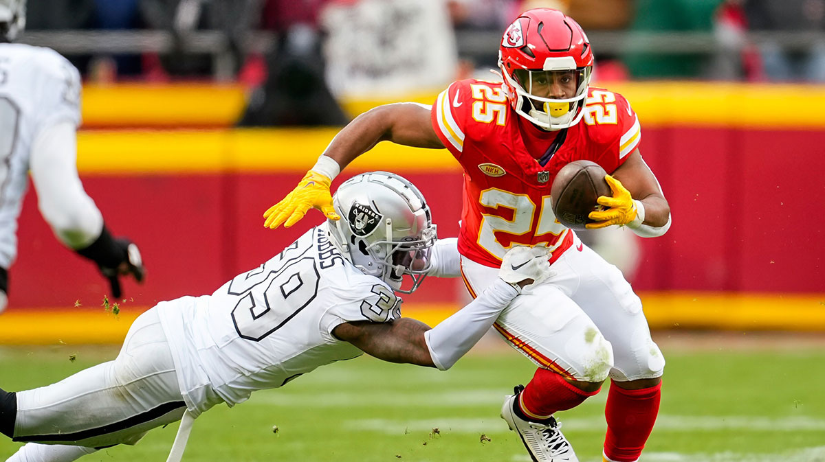 Kansas City Chiefs running back Clyde Edwards-Helaire (25) runs the ball against Las Vegas Raiders cornerback Nate Hobbs (39) during the second half at GEHA Field at Arrowhead Stadium.