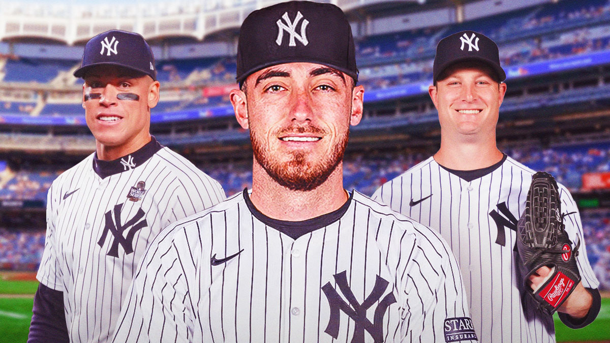 Cody Bellinger in a Yankees jersey. Yankees Aaron Judge, Yankees Gerrit Cole both in background smiling.