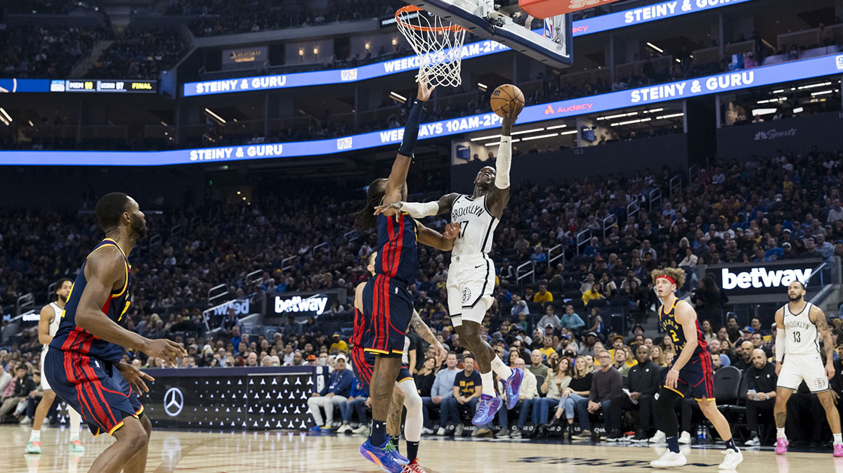 Brooklyn Nets guard Dennis Schroder (17) shoots as Golden State Warriors forward Kevon Looney (5) defends during the first half at Chase Center.