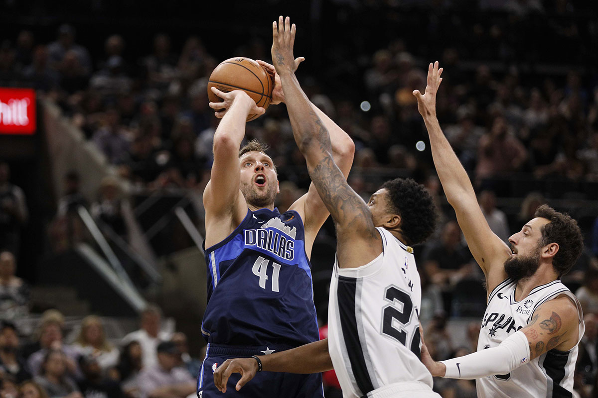 Dallas Mavericks power forward Dirk Nowitzki (41) shoots the ball over San Antonio Spurs small forward Rudy Gay (22) and Marco Belinelli (right) during the second half at AT&T Center. 