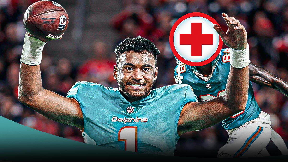 Tua Tagovailoa with his hands on his head. Grant Dubose in the background with a first aid logo over his head. Inside NRG Stadium.