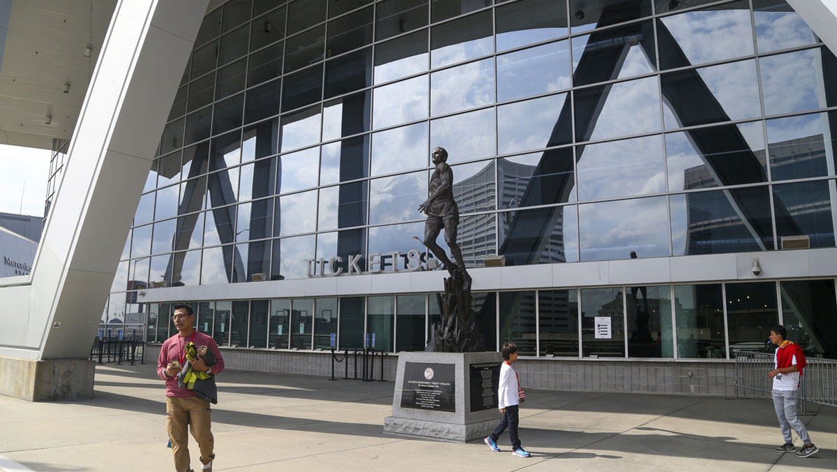 Fans walk the statues of the former NBA player Dominique Wilkins in front of the State Farm Arena, where the game between Cleveland Cavaliers and Atlanta Hawks was canceled after the NBA season was suspended due to corroded coronavirus.