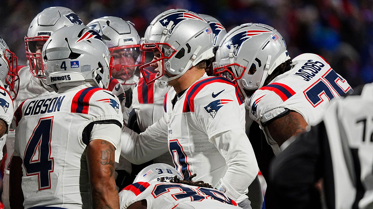 New England Patriots quarterback Drake Maye (10) throws a pass under pressure from Buffalo Bills safety Cole Bishop (24) and linebacker Dorian Williams (42) in the fourth quarter at Highmark Stadium.