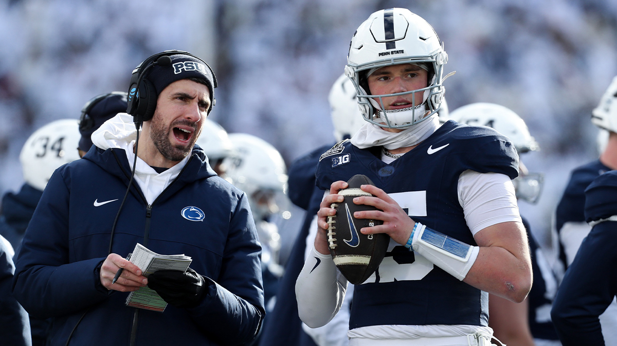 Penn State Nittany Lions quarterback Drew Allar (15) warms up on the sideline while listening to quarterback coach Danny O'Brien (left) during the first quarter against the Southern Methodist Mustangs in the first round of the College Football Playoff at Beaver Stadium.