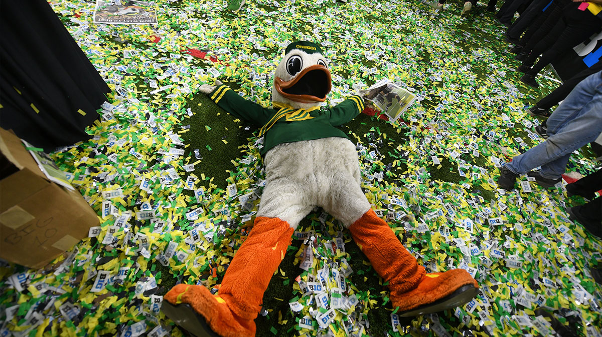 The Oregon Duck mascot makes snow angels in confetti after defeating the Penn State Nittany Lions to win the Big Ten Championship in the 2024 Big Ten Championship game at Lucas Oil Stadium.