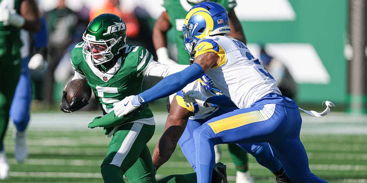 New York Jets wide receiver Garrett Wilson (5) gains yards after catch as Los Angeles Rams safety Kamren Curl (3) pursues during the first half at MetLife Stadium