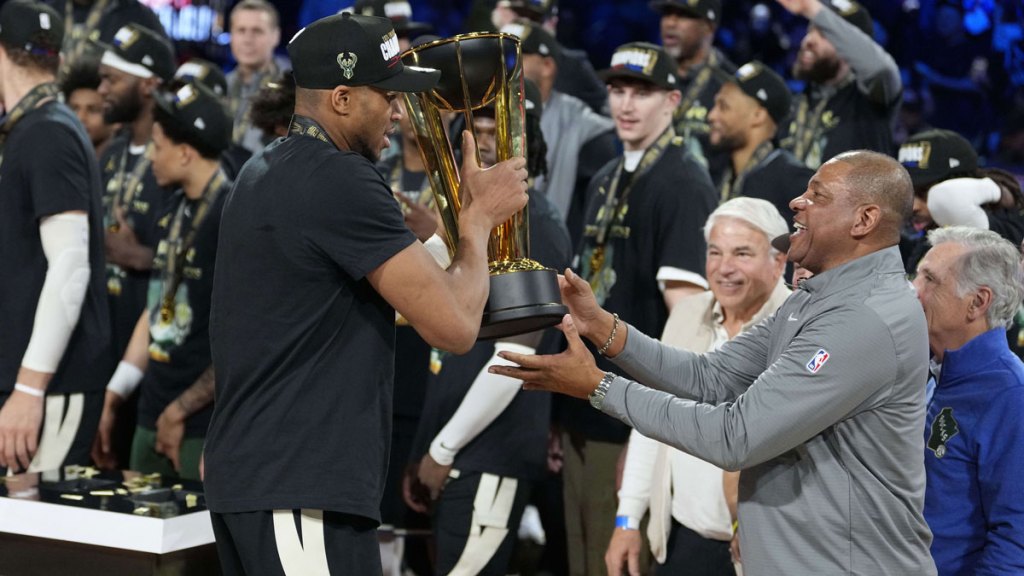 Milwaukee Bucks forward Giannis Antetokounmpo (34) hands the trophy to head coach Doc Rivers after winning the Emirates NBA Cup championship game against the Oklahoma City Thunder at T-Mobile Arena. 