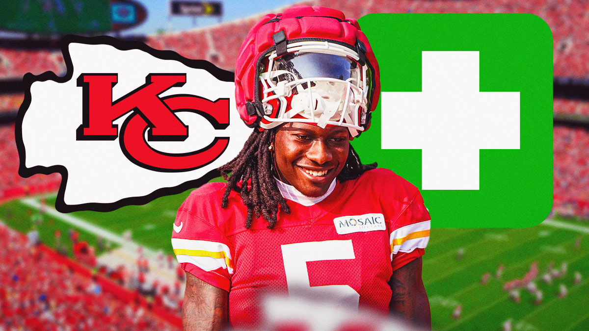 Chiefs WR Hollywood Brown smiling/happy with Chiefs logo behind him and green medical cross. Background is Arrowhead stadium.