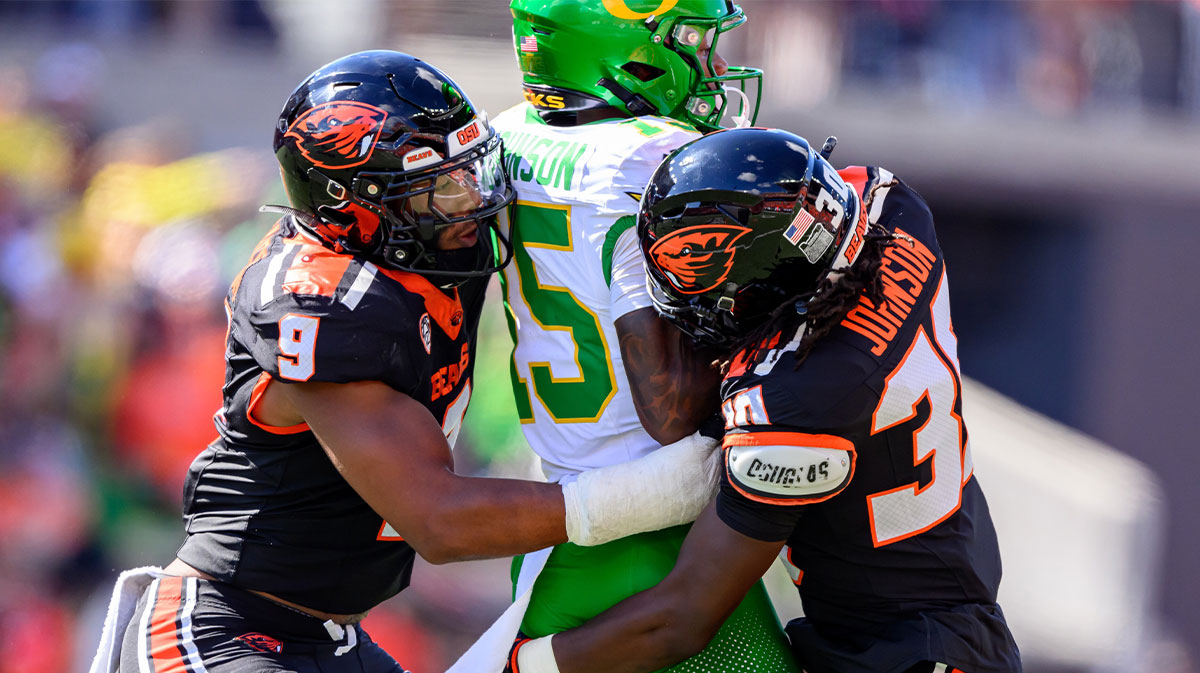 Sep 14, 2024; Corvallis, Oregon, USA; Oregon State Beavers linebacker Isaiah Chisom (9) and defensive back Josiah Johnson (30) tackle Oregon Ducks wide receiver Tez Johnson (15) after a catch during the second half at Reser Stadium. Mandatory Credit: Craig Strobeck-Imagn Images