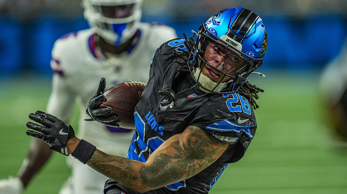 Detroit Lions running back Jahmyr Gibbs (26) tip toes along th sideline to get a first down on a back toss from Detroit Lions wide receiver Amon-Ra St. Brown (14) in a trick play iduring the second half at Ford Field in Detroit on Sunday, Dec. 15, 2024.