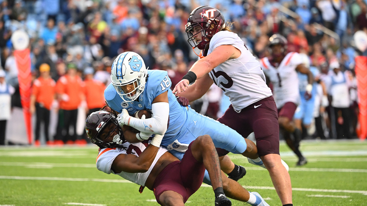 North Carolina Tar Heels tight end Bryson Nesbit (18) makes a catch as Virginia Tech Hokies defensive back Jalen Stroman (26) and linebacker Dax Hollifield (25) defend in the third quarter at Kenan Memorial Stadium.