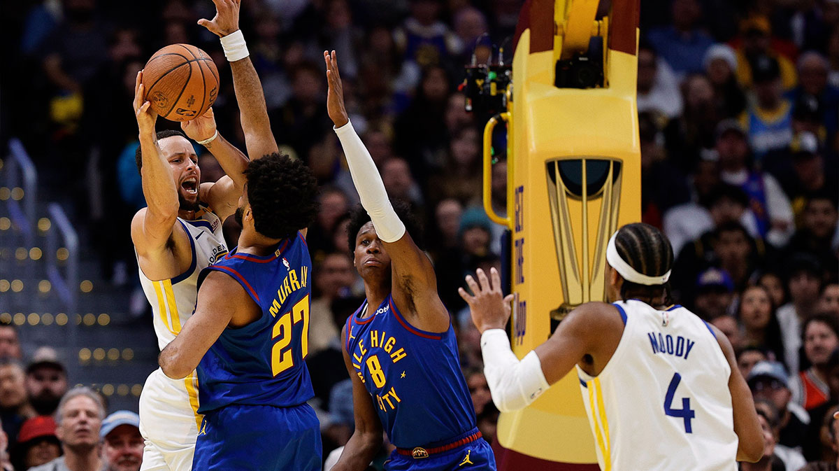 Golden State Warriors guard Stephen Curry (30) attempts to pass the ball to guard Moses Moody (4) while Denver Nuggets guard Jamal Murray (27) and forward Peyton Watson (8) in the fourth Defend quarters in the ball arena. 