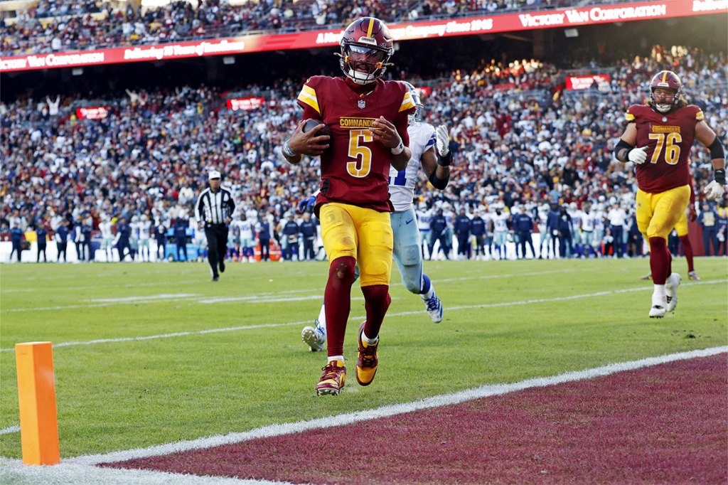 Washington Commanders quarterback Jayden Daniels (5) scores a two point conversion during the fourth quarter against the Dallas Cowboys at Northwest Stadium. 