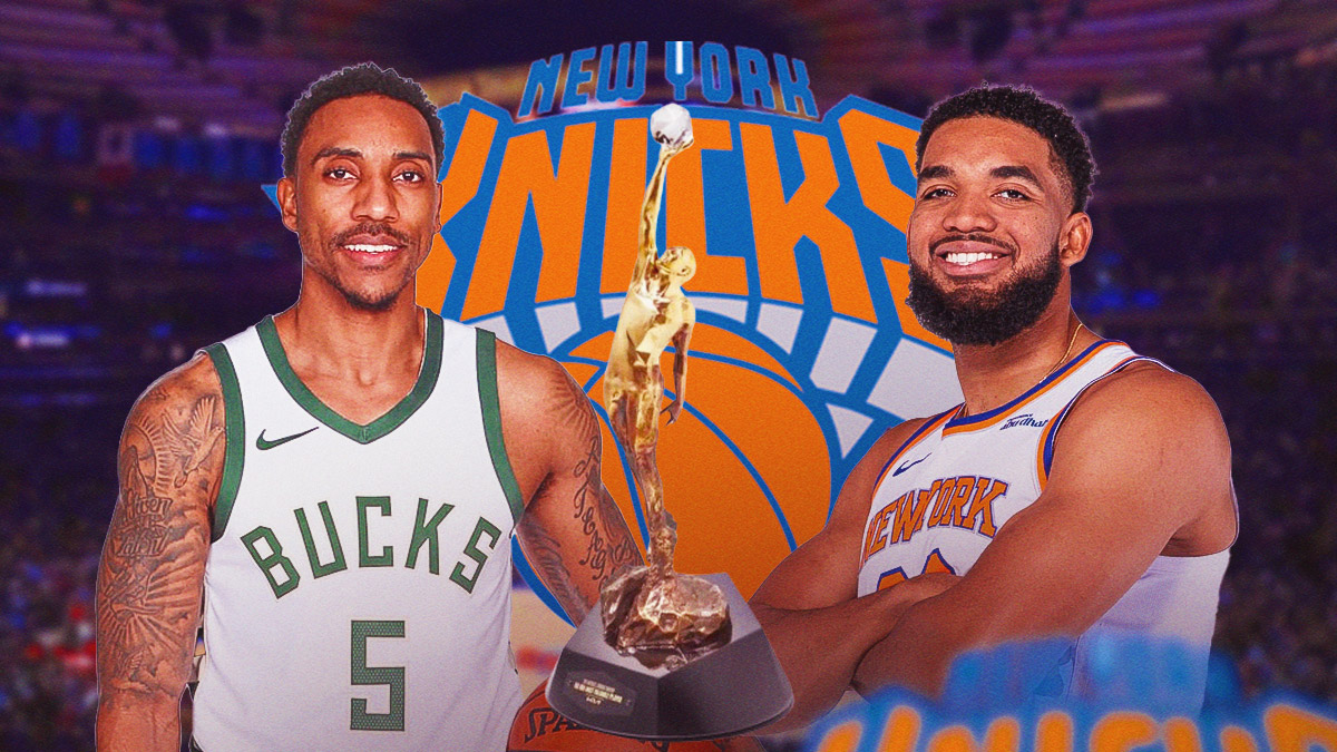 Jeff Teague smiling next to Knicks center Karl-Anthony Towns with the MVP trophy next to them & the Knicks logo in the background