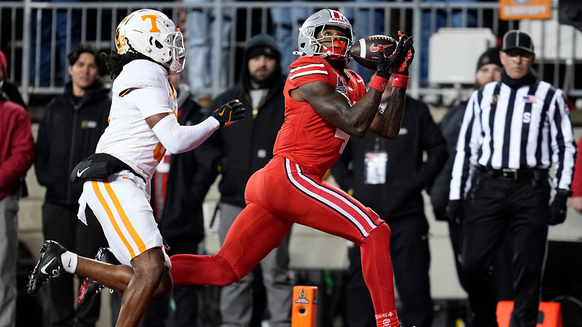 Ohio State Buckeyes wide receiver Jeremiah Smith (4) catches a touchdown pass in front of Tennessee Volunteers defensive back Jermod McCoy (3) during the second half of the College Football Playoff first round game at Ohio Stadium in Columbus on Dec. 22, 2024. Ohio State won 42-17.