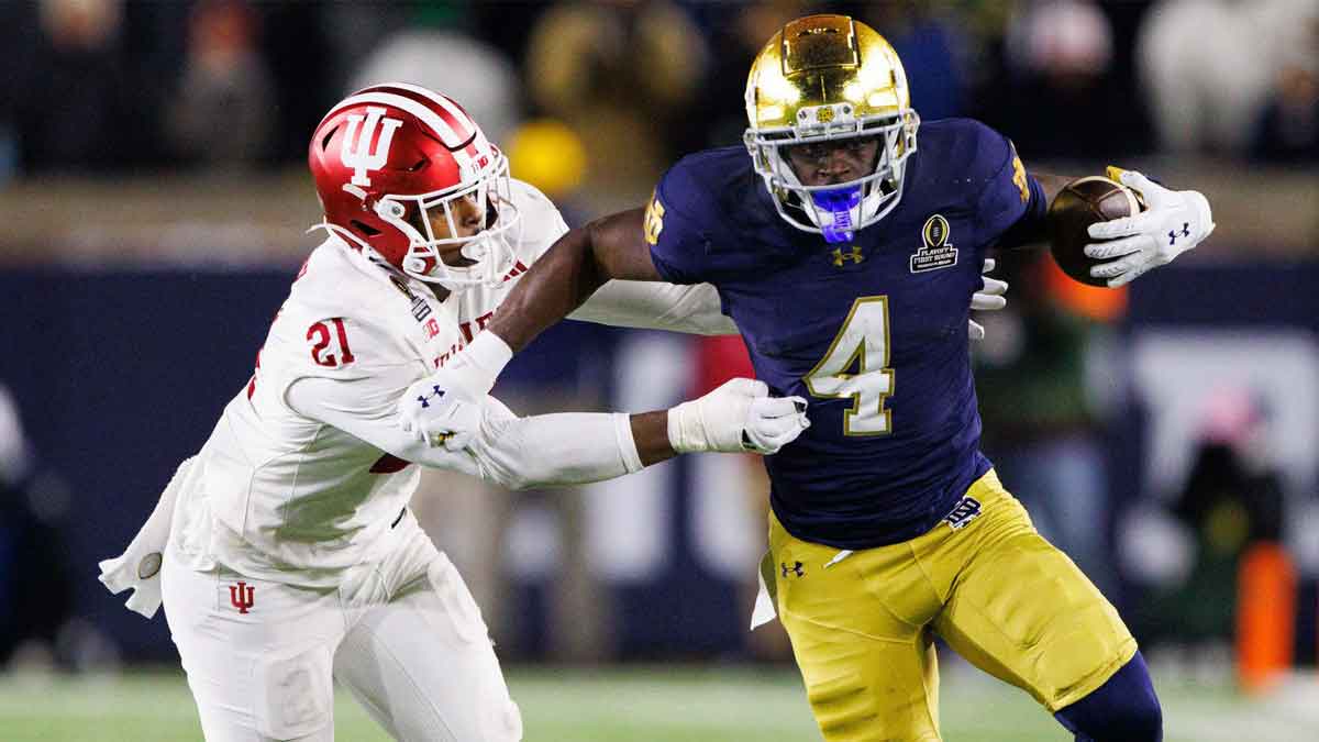 Notre Dame running back Jeremiyah Love (4) runs the ball past Indiana linebacker Rolijah Hardy (21) during the first round of the College Football Playoff between Notre Dame and Indiana at Notre Dame Stadium