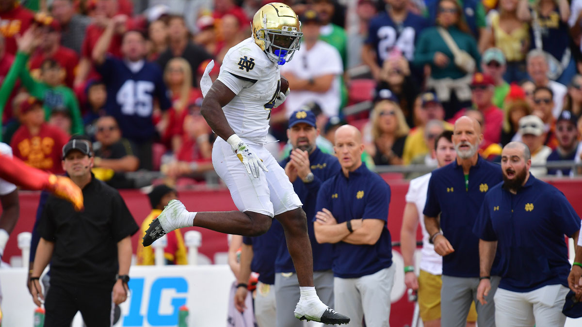 Notre Dame Fighting Irish running back Jeremiyah Love (4) jumps over Southern California Trojans safety Kamari Ramsey (7) during the first half at the Los Angeles Memorial Coliseum.