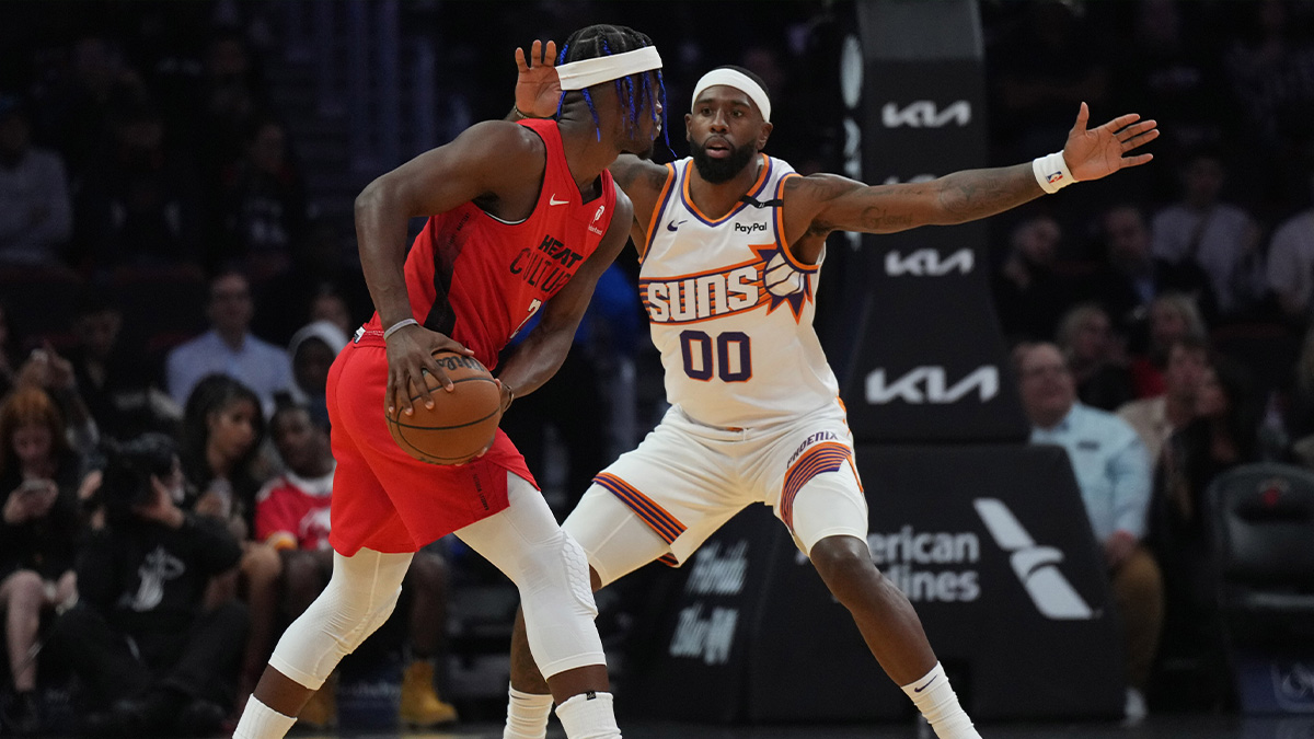 Miami Heat forward Jimmy Butler (22) controls the ball against Phoenix Suns forward Royce O'Neale (00) during the first half at Kaseya Center.