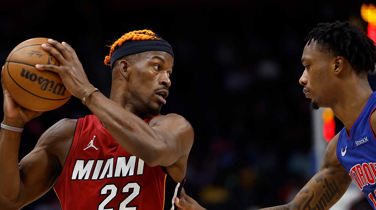 Miami Heat forward Jimmy Butler (22) controls the ball as Detroit Pistons forward Ronald Holland II (00) defends in the first half at Little Caesars Arena.